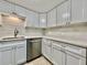 Modern kitchen featuring sleek white cabinetry, stainless steel appliances, and bright subway tile backsplash at 2459 Columbia Dr # 17, Clearwater, FL 33763