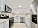 Updated kitchen with stainless steel appliances, white cabinets, and a clean, modern design at 2459 Columbia Dr # 17, Clearwater, FL 33763