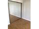 Bedroom closet with sliding mirrored doors and wood-look flooring at 2625 State Road 590 # 1822, Clearwater, FL 33759