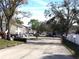 Street view of the Coachman Creek Condominium community with mature trees at 2625 State Road 590 # 1822, Clearwater, FL 33759