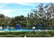 Community pool surrounded by lush landscaping, lounge chairs, and shaded umbrellas at 2625 State Road 590 # 1822, Clearwater, FL 33759