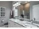 Bright bathroom featuring double sinks with granite countertops and a glass shower at 2990 Eagle Estates W Cir, Clearwater, FL 33761
