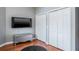 Bedroom featuring hardwood floors, closet and a large TV at 2990 Eagle Estates W Cir, Clearwater, FL 33761