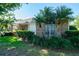 Charming home exterior with brick accents, manicured landscaping, and mature palm trees in the front yard at 2990 Eagle Estates W Cir, Clearwater, FL 33761