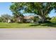 Single-story home features a brick facade, mature trees, and well-manicured lawn at 2990 Eagle Estates W Cir, Clearwater, FL 33761