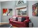 Bright and inviting living room with a large window, plush red couch and stylish decor at 2990 Eagle Estates W Cir, Clearwater, FL 33761