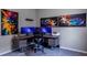 A spacious home office with modern desk, multiple monitors, and colorful artwork at 2990 Eagle Estates W Cir, Clearwater, FL 33761