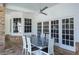 Spacious covered patio featuring an outdoor dining set and view of the landscaped yard through glass doors at 2990 Eagle Estates W Cir, Clearwater, FL 33761