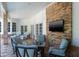 Comfortable covered patio featuring a brick wall, outdoor seating and a wall-mounted television at 2990 Eagle Estates W Cir, Clearwater, FL 33761