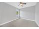This carpeted bedroom features neutral walls, white baseboards, and a view from the window at 3002 E 24Th Ave, Tampa, FL 33605