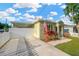 Home exterior featuring a lush lawn, American flag, and a long driveway with white privacy fence and carport at 3002 E 24Th Ave, Tampa, FL 33605