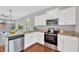 Modern kitchen features stainless steel appliances, granite countertops, and ample white cabinetry at 3002 E 24Th Ave, Tampa, FL 33605