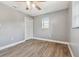 Bright bedroom featuring gray walls, wood-look floors, ceiling fan, and closet at 30229 Coast Ln, Wesley Chapel, FL 33545