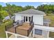 A spacious deck with black railing features chairs and views of the lush surroundings at 30229 Coast Ln, Wesley Chapel, FL 33545