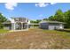A two-story home with a second-floor deck, carport, and connection to a grey brick garage at 30229 Coast Ln, Wesley Chapel, FL 33545
