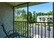 View from the balcony of a condo with a view of a parking lot and lots of green trees at 3166 Lake Pine S Way # E3, Tarpon Springs, FL 34688