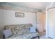 Well-lit bedroom featuring a futon with accent pillows, and a door to the hallway at 3166 Lake Pine S Way # E3, Tarpon Springs, FL 34688