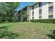 Manicured lawn, mature trees, and a well-maintained condominium complex at 3166 Lake Pine S Way # E3, Tarpon Springs, FL 34688