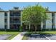 Low-rise condominium building with well-maintained landscaping, parking, and walkway to the entrance at 3166 Lake Pine S Way # E3, Tarpon Springs, FL 34688