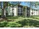 Condominium exterior with mature trees and well-manicured landscaping at 3166 Lake Pine S Way # E3, Tarpon Springs, FL 34688