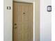 Neutral painted front door with a digital lock and decorative light at 3166 Lake Pine S Way # E3, Tarpon Springs, FL 34688