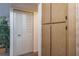 Hallway with wooden cabinets, a white closet with louvered doors, and a large potted plant at 3166 Lake Pine S Way # E3, Tarpon Springs, FL 34688