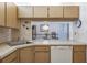 View of the kitchen from the dining area, showcasing a dishwasher, and wooden cabinets at 3166 Lake Pine S Way # E3, Tarpon Springs, FL 34688