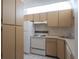 Efficient kitchen with light cabinets, white appliances, and easy-to-clean tile floors at 3166 Lake Pine S Way # E3, Tarpon Springs, FL 34688