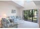 Sunlit living room featuring comfortable sofas, and a balcony with outdoor views at 3166 Lake Pine S Way # E3, Tarpon Springs, FL 34688
