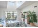 Cozy living area with a vaulted ceiling, balcony access, and lush green views at 3166 Lake Pine S Way # E3, Tarpon Springs, FL 34688