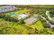 An aerial view showcases a community pool, tennis courts, and lush green spaces for recreation and relaxation at 3243 Ashmonte Dr, Land O Lakes, FL 34638