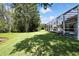 Lush backyard with a screened-in pool area, mature trees, and a tranquil pond view at 3243 Ashmonte Dr, Land O Lakes, FL 34638