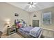 Cozy bedroom features neutral walls, ceiling fan, carpet, and a window at 3243 Ashmonte Dr, Land O Lakes, FL 34638