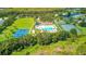 Aerial view showcases an amazing community center with a pool, tennis court and sports courts at 3243 Ashmonte Dr, Land O Lakes, FL 34638