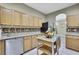 Kitchen with wooden cabinets, granite countertops, stainless steel dishwasher, and tile flooring at 3243 Ashmonte Dr, Land O Lakes, FL 34638