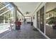 Covered patio with brick flooring leading to the screened pool and spa area with BBQ grill at 3243 Ashmonte Dr, Land O Lakes, FL 34638