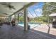 The covered patio offers ample space for entertaining and overlooks the screened pool, spa, and pond at 3243 Ashmonte Dr, Land O Lakes, FL 34638