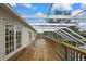 Expansive screened deck with wood flooring, offering picturesque views of the backyard and waterfront at 3243 Ashmonte Dr, Land O Lakes, FL 34638