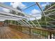 Wide wooden deck with screen overlooking the pool and lake beyond at 3243 Ashmonte Dr, Land O Lakes, FL 34638