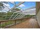 Spacious screened-in porch featuring a beautiful wood deck, railing, and a view of the lush backyard at 3243 Ashmonte Dr, Land O Lakes, FL 34638