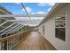 Large screened-in deck with wood flooring and white frame, extending along the house with windows at 3243 Ashmonte Dr, Land O Lakes, FL 34638