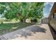 View of the brick paved patio and spacious backyard with mature trees, and screened lanai of the home at 3262 Montclair Cir, North Port, FL 34287