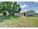 Exterior rear view of the home with a large tree in the yard, and outdoor patio at 3262 Montclair Cir, North Port, FL 34287