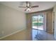 Cozy bedroom features tile floors, a ceiling fan, and a patio view at 3262 Montclair Cir, North Port, FL 34287