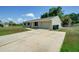Single-story home with a driveway, attached garage, and green lawn on a sunny day at 3262 Montclair Cir, North Port, FL 34287