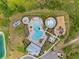 Aerial view of a community pool with lounge chairs, a splash pad, and a playground at 33581 Elm Hill Br, Wesley Chapel, FL 33545
