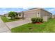 Well-manicured lawn with professional landscaping leading up to an attached two car garage at 33581 Elm Hill Br, Wesley Chapel, FL 33545