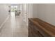 Hallway leading to the living area featuring tile flooring and a rustic wood dresser at 33581 Elm Hill Br, Wesley Chapel, FL 33545