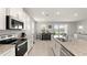 Bright kitchen features white cabinetry, granite counters, a stainless sink and a view of the backyard at 33581 Elm Hill Br, Wesley Chapel, FL 33545