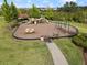 Community playground featuring swings, slides, and other play structures surrounded by lush landscaping at 33581 Elm Hill Br, Wesley Chapel, FL 33545